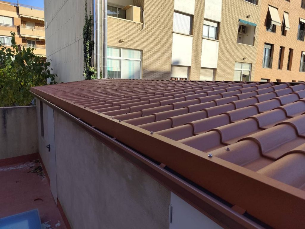 Técnico realizando mantenimiento de canalones en una vivienda de Caldes d’Estrac, limpiando residuos y revisando el sistema de evacuación pluvial.
